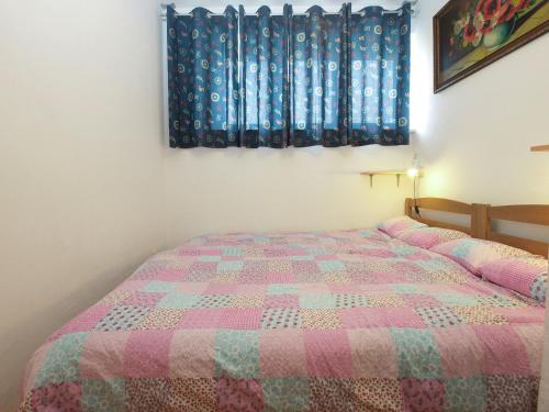 een slaapkamer met een bed met een roze quilt bij Apartment Suzana 1849 in Fažana