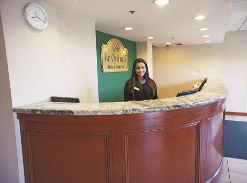 una mujer parada detrás de un bar en una sala de espera en La Quinta by Wyndham Stamford / New York City, en Stamford