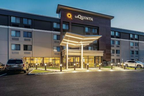 a hotel with a lit up building with a lioninia sign at La Quinta by Wyndham Salem NH in Salem