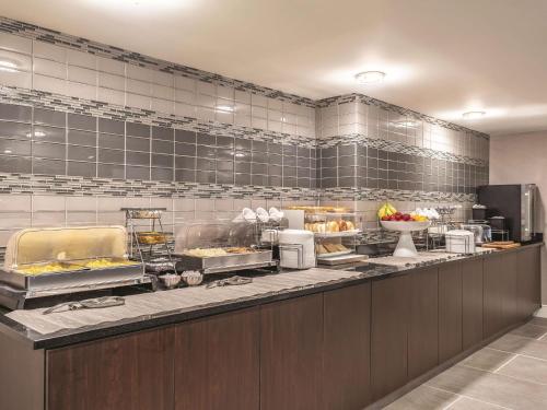 um restaurante com uma linha de buffet com comida em La Quinta by Wyndham Columbia / Fort Meade em Jessup