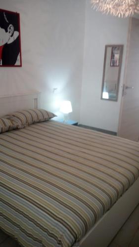 una camera da letto con un letto a righe di casa nonna Emma a Iglesias