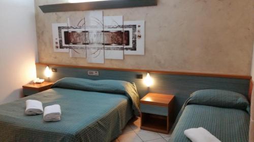 two beds in a hotel room with green beds at Albergo Al Cacciatore in Desenzano del Garda