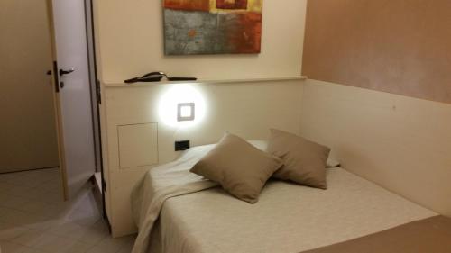 a small bed with two pillows in a room at Albergo Al Cacciatore in Desenzano del Garda