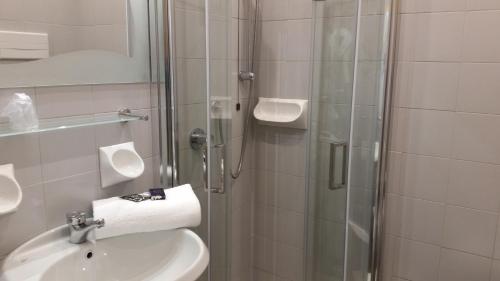 a bathroom with a shower and a sink and a toilet at Albergo Al Cacciatore in Desenzano del Garda