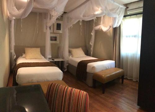 a hotel room with two beds and a couch at Vila Sol e Sal in Vilanculos