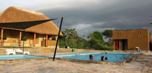 a group of people in a swimming pool at Fort Murchison Lodge by NATURE LODGES LTD in Pakwach East