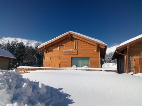 una cabaña de madera en la nieve con un montón de nieve en Rifugio Il Ginepro dell'Etna en Linguaglossa