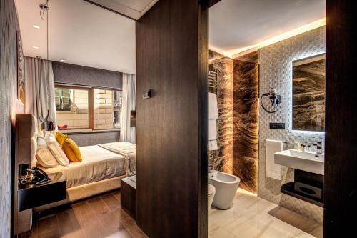 - une chambre avec un lit et une salle de bains pourvue d'un lavabo dans l'établissement Prassede Palace Hotel, à Rome