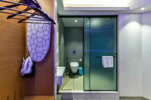 a bathroom with a glass shower and a toilet at Indie Stays, BKC in Mumbai