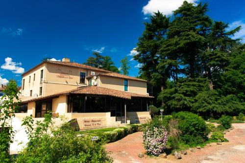 a large building with trees in the background at Hôtel Restaurant du Château de la Tour in Béguey