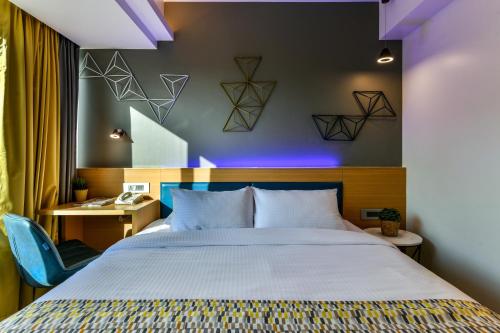 a bedroom with a large bed and a desk with a chair at Indie Stays, BKC in Mumbai