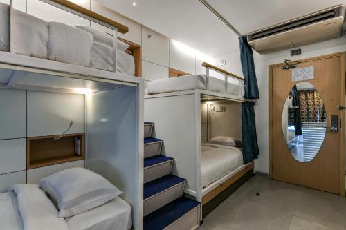 a room with two bunk beds and a mirror at Indie Stays, BKC in Mumbai