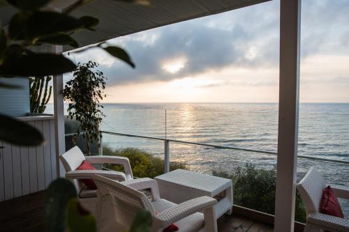 a balcony with chairs and a table and a view of the ocean at Hotel Boutique Milla de Plata in Torreguadiaro