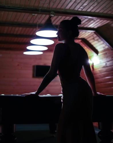 a woman standing in front of a bed in a dark room at Georgiy in Oryavchyk