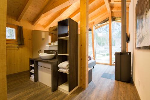 MuotathalにあるHüttenhotel Husky Lodgeの洗面台付きの小さな家のバスルーム1室
