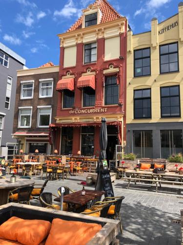 eine Terrasse vor einem Gebäude mit Tischen und Stühlen in der Unterkunft Slapen bij Café de Concurrent in Vlissingen