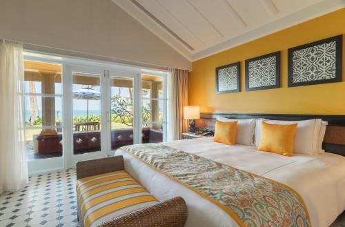 ein Schlafzimmer mit einem großen Bett und einem Balkon in der Unterkunft Taj Holiday Village Resort & Spa, Goa in Candolim