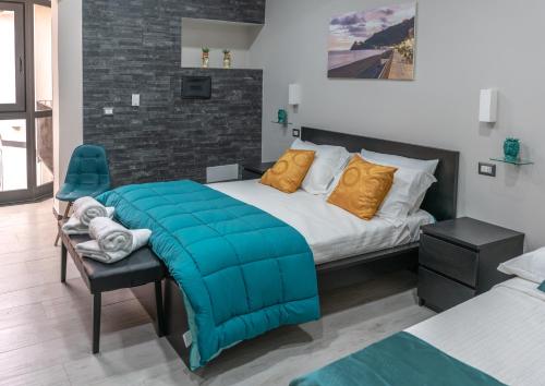 a bedroom with a bed with a blue blanket on it at Marranzanu Rooms in Santa Teresa di Riva