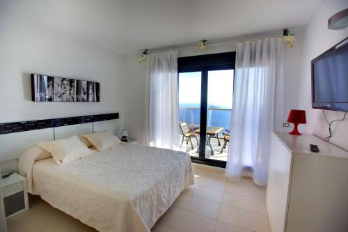 a bedroom with a bed and a view of the ocean at Benidorm Skyline in Benidorm