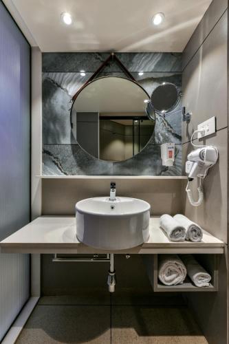 a bathroom with a sink and a mirror at Indie Stays, BKC in Mumbai