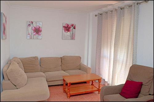 - un salon avec un canapé et une table dans l'établissement Dalí al Mar, à Conil de la Frontera