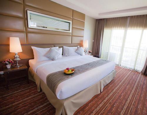 a hotel room with two beds and a window at Intimate Hotel Pattaya - SHA Extra Plus in Pattaya
