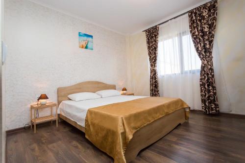 a bedroom with a large bed and a window at Sorriso Mamaia Nord in Mamaia Nord