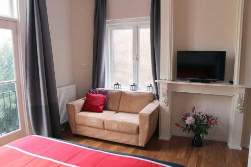 a living room with a couch and a television at B&B Utrecht Domkwartier in Utrecht