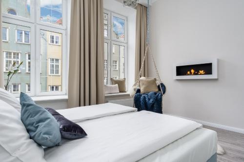 グダニスクにあるElite Apartments Piwna Premiumのベッドルーム(スイングベッド、暖炉付)