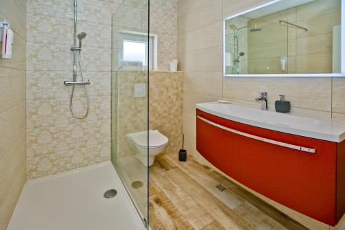 a bathroom with a red sink and a shower at Apartments Bubalo in Hvar