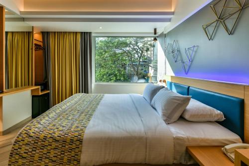 a bedroom with a large bed and a window at Indie Stays in Mumbai