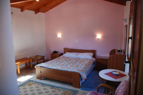 a bedroom with a bed and a table in it at Hotel Bonis in Samos