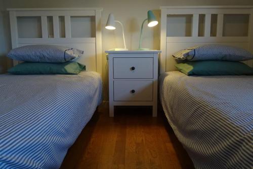 - une chambre avec 2 lits et une table de chevet dans l'établissement Margarida Charming House in Cascais, à Cascais