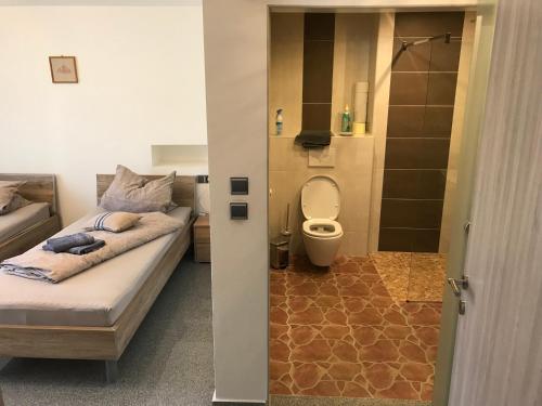 bagno con letto e servizi igienici in camera. di Apartment Ereiz a Hermagor