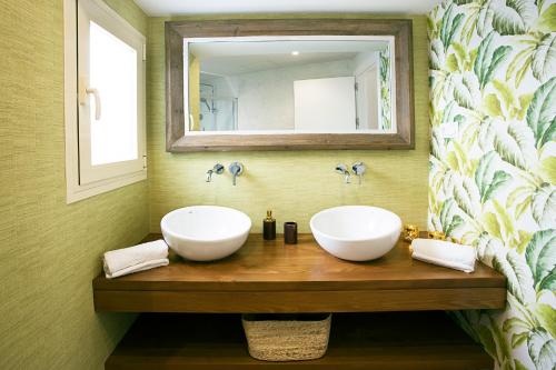 a bathroom with two sinks and a mirror at Graffiti Suites Málaga in Málaga