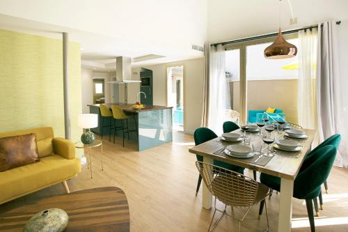 a dining room and living room with a table and chairs at Graffiti Suites Málaga in Málaga
