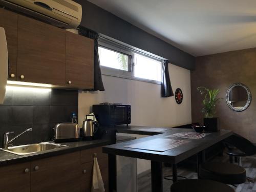 Una pequeña cocina con una mesa y un fregadero. en The room, en Lárnaca