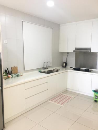 a white kitchen with white cabinets and a sink at DaMen Homestay @SubangHomeStay in Subang Jaya