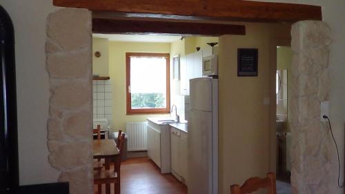 Il comprend une cuisine équipée d'un réfrigérateur, d'un évier et d'une fenêtre. dans l'établissement Gite Rammelstein, à Ribeauvillé