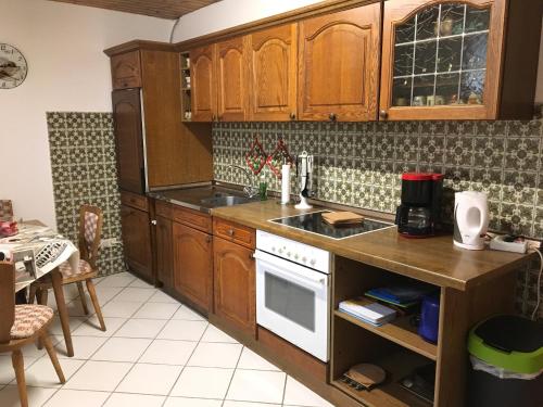 a kitchen with wooden cabinets and a stove top oven at Grosses Ferienhaus im Westerwald in Mengerskirchen