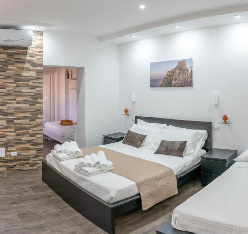 a bedroom with two beds and a brick wall at B&B Marranzanu in Santa Teresa di Riva