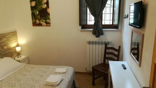 a small room with a bed and a table and a chair at BorgoPratole CountryHouse in Cingoli