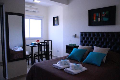 1 dormitorio con 1 cama con 2 toallas en Villa Cabrera Apart and Suites en Córdoba