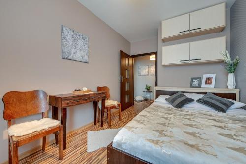 sypialnia z łóżkiem, biurkiem i stołem w obiekcie Blue Mandarin City Wood Gdynia w mieście Gdynia