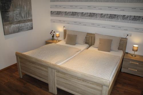 two beds in a bedroom with two lamps on the tables at Alte - Post - Hotel in Schöppingen