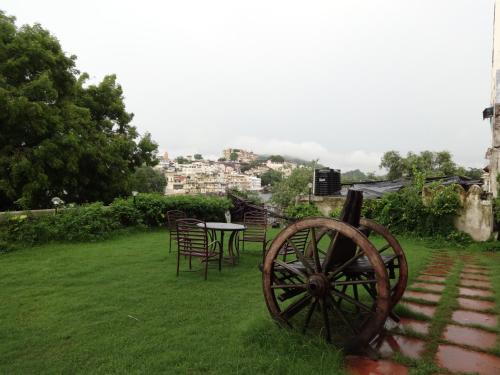 a table and chairs in a yard with aokedoked wheel at Karohi Haveli - A Heritage Hotel in Udaipur