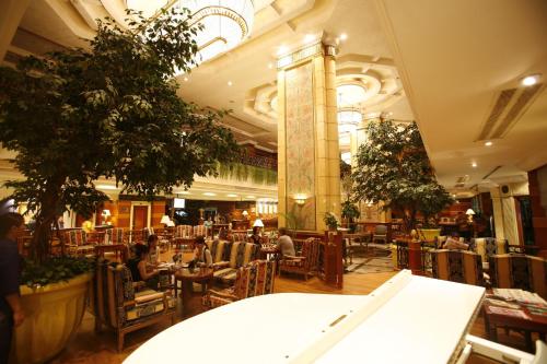 a restaurant with people sitting in chairs in a building at Golden Tulip Sovereign Hotel Bangkok in Bangkok