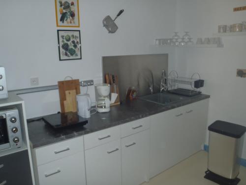 une cuisine avec des armoires blanches et un comptoir dans l'établissement SEA and BOAT, à Le Portel