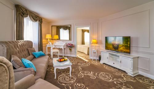 sala de estar con sofá y TV de pantalla plana en Don Giovanni Hotel Prague - Great Hotels of The World, en Praga