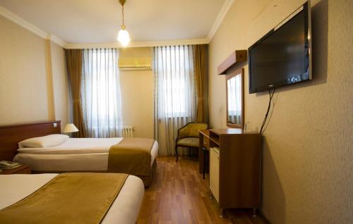 Habitación de hotel con 2 camas y TV de pantalla plana. en Saban Acikgoz Hotel, en Edirne